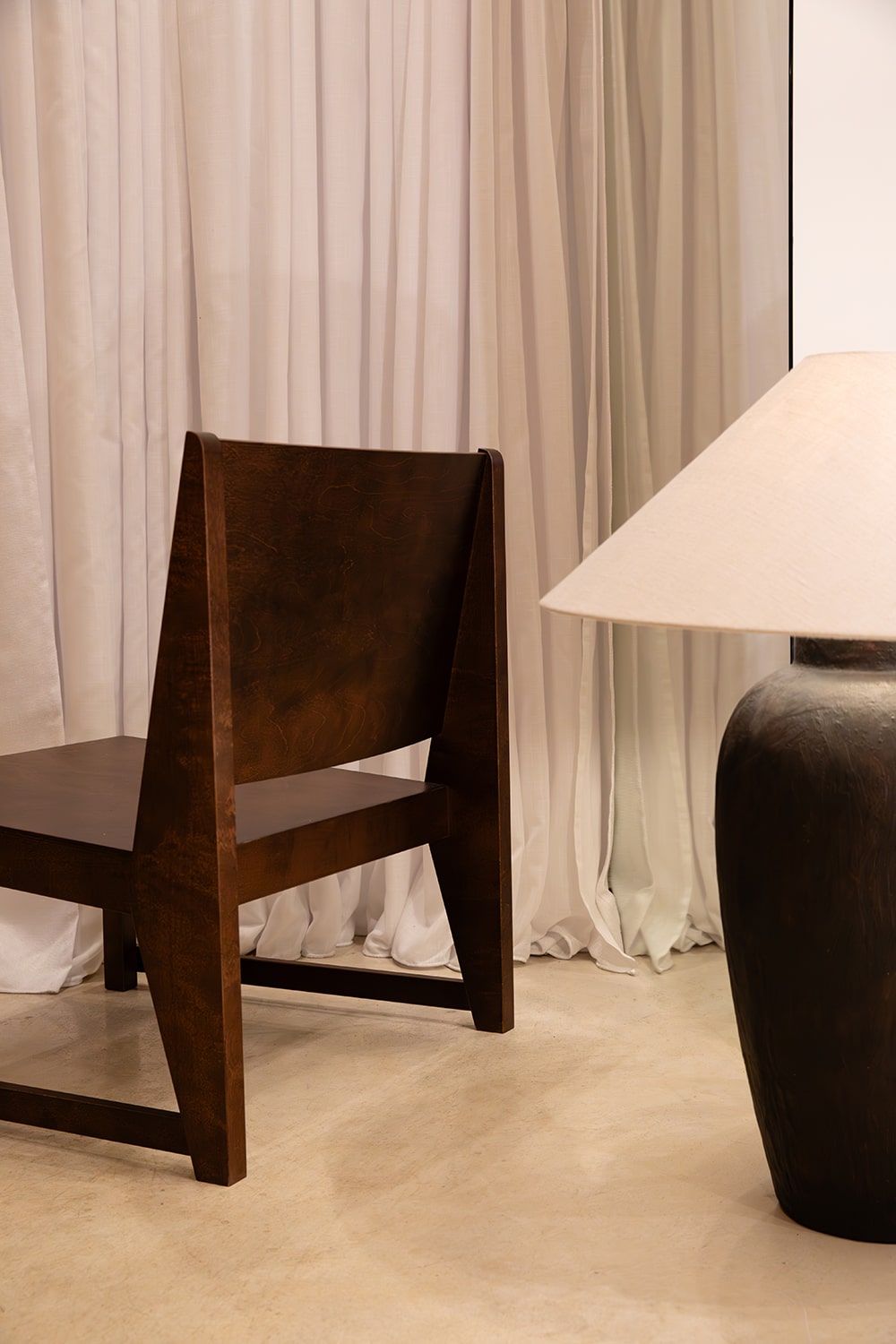 Fotografía profesional de interiores con silla de diseño y lámpara en espacio minimalista