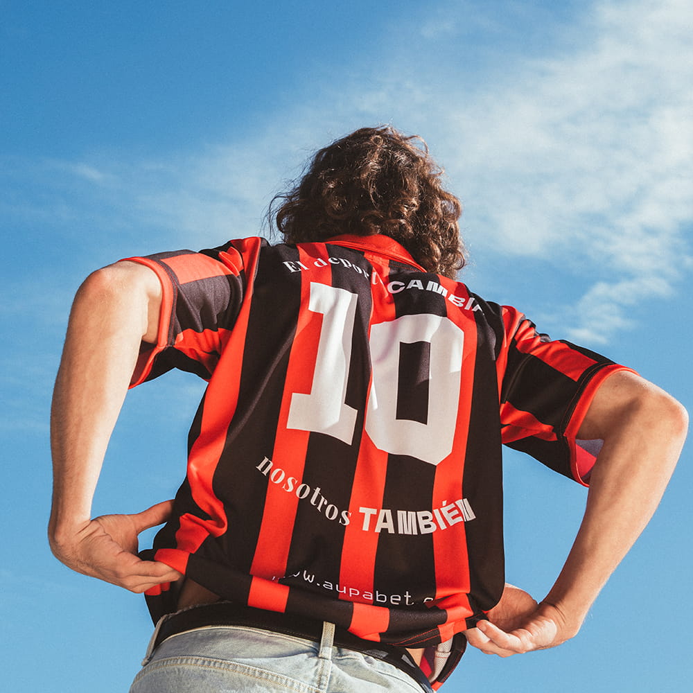 Fotografía de moda deportiva con modelo masculino mostrando camiseta corporativa personalizada en exterior