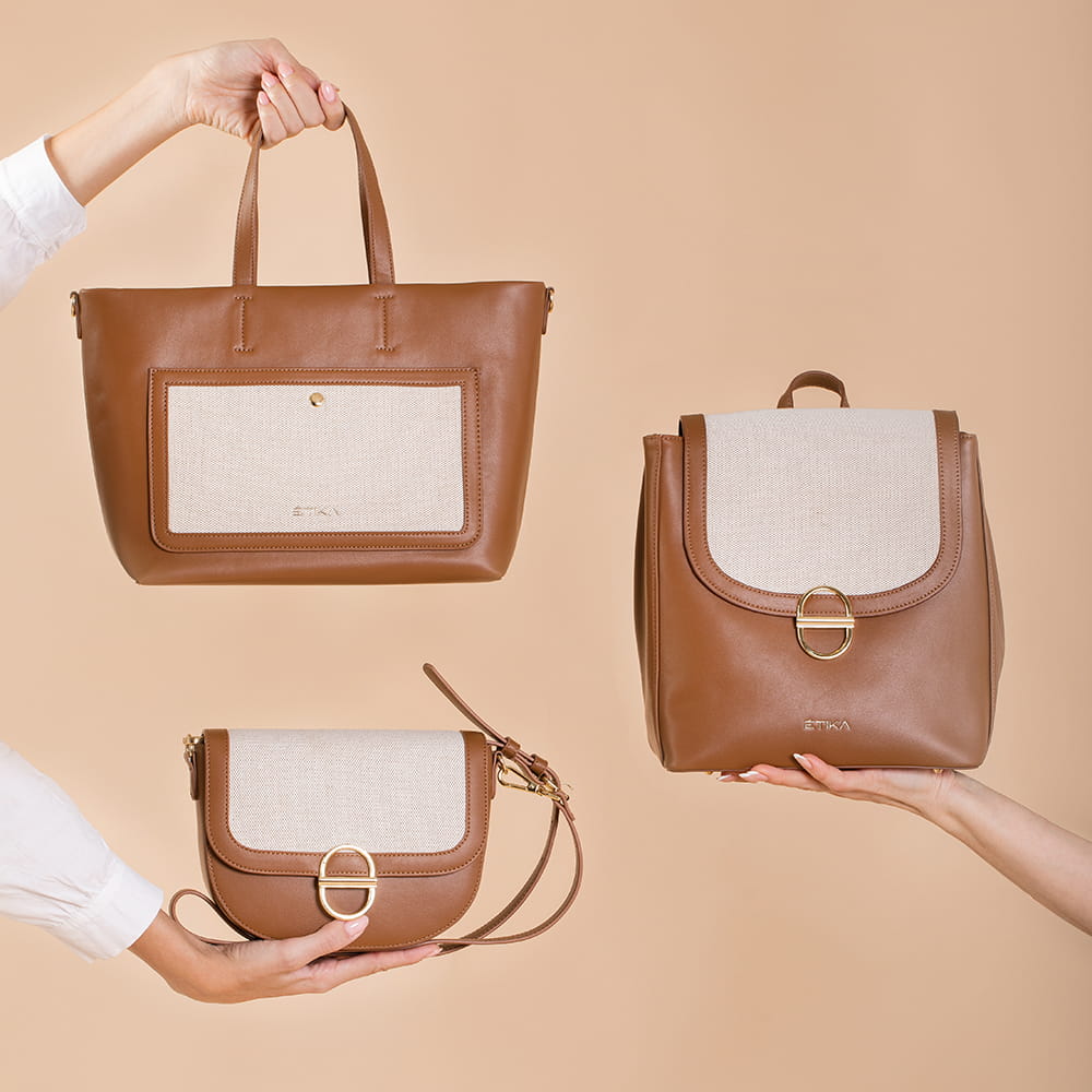 Fotografía de bolsos Etika en piel marrón con detalles beige sobre fondo liso en tonos nude