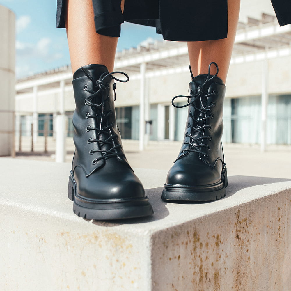 Fotografía de moda de botas negras de cordones en exterior con luz natural