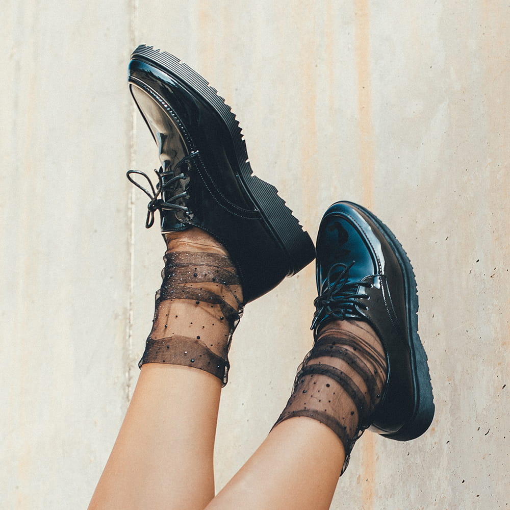 Fotografía editorial de zapatos negros con calcetines de tul
