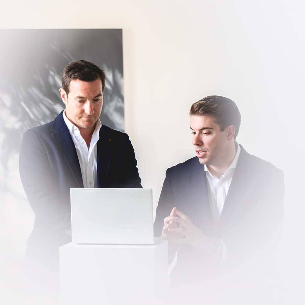 Trabajadores de Carrillo Abogados reunidos revisando documentación en portátil en despacho profesional