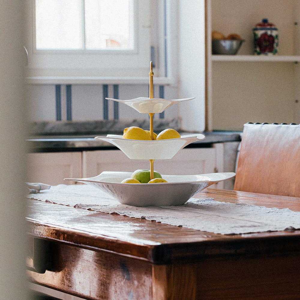 Fotografía de interiores de comedor con mesa de madera y cocina luminosa al fondo