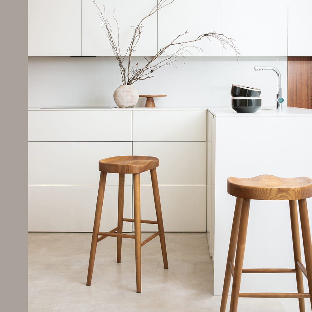 Fotografía de interiores de cocina moderna minimalista con taburetes de madera y mobiliario blanco