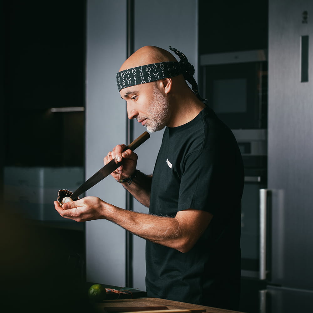 Cocinero profesional preparando sushi en cocina moderna durante sesión de fotografía de marca personal
