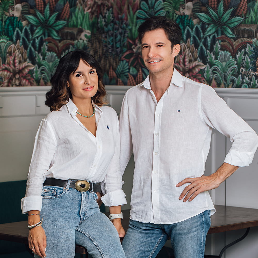 Retrato corporativo de dos empresarios de una marca de cosmética posando en interior con fondo decorativo