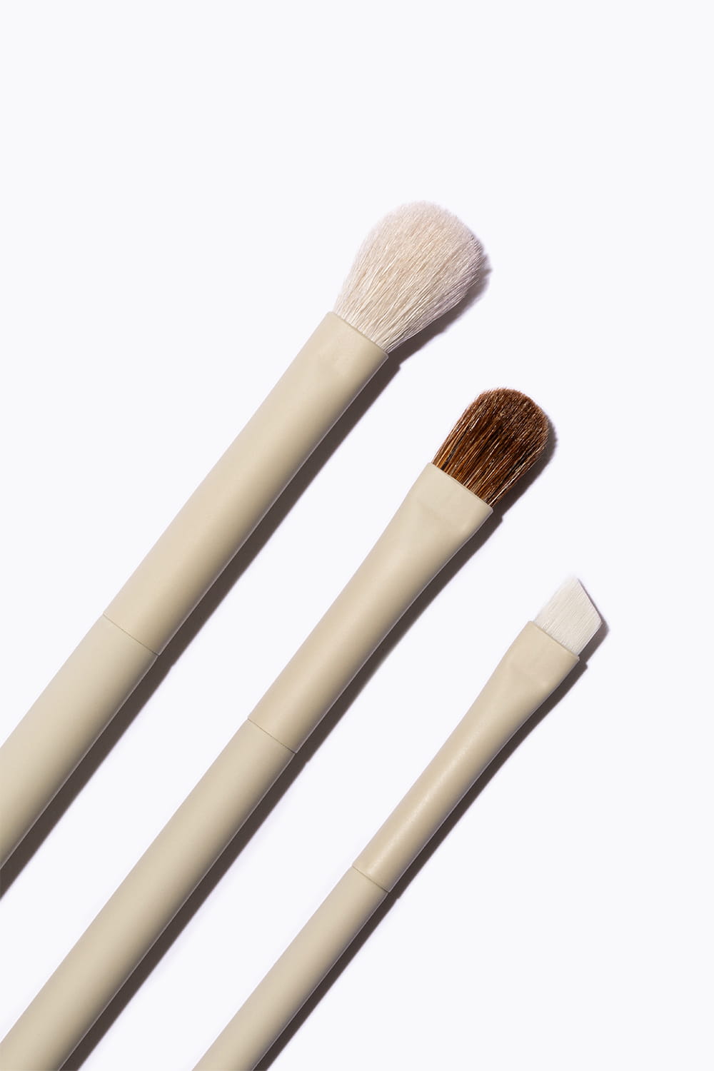 Fotografía de brochas de maquillaje en fondo neutro minimalista