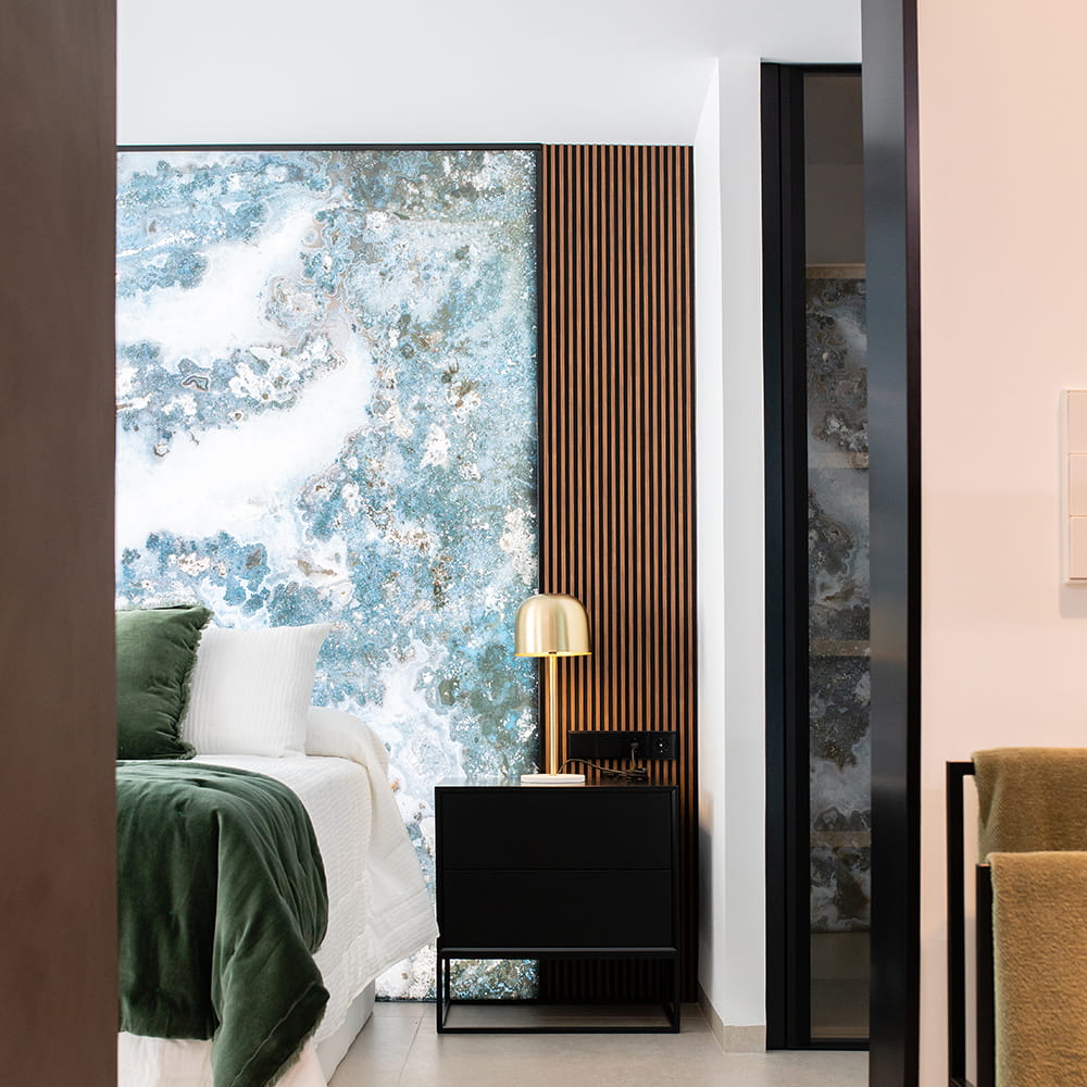 Fotografía de interiores de dormitorio moderno con decoración de diseño, cabecero artístico y luz cálida