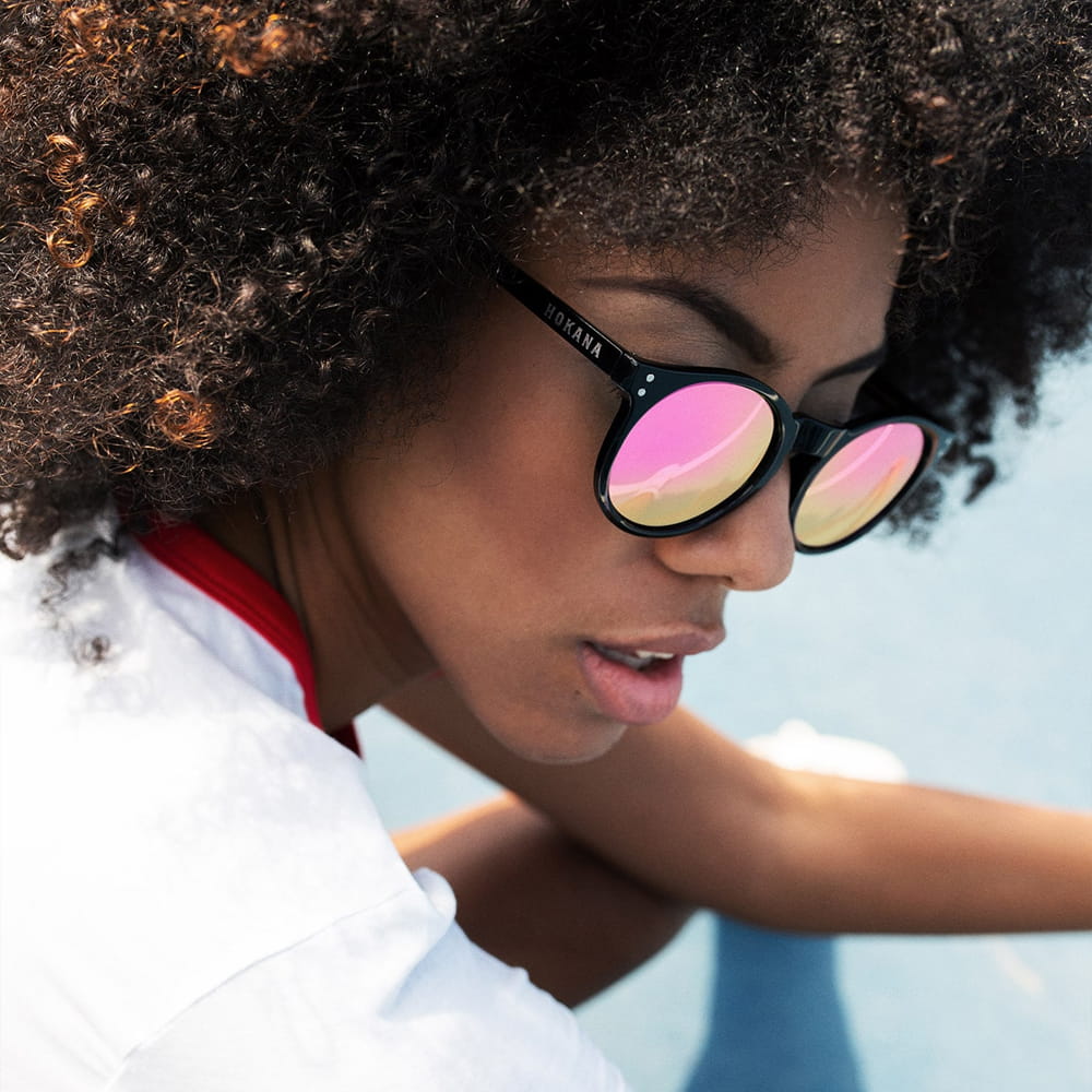 Fotografía de moda lifestyle con modelo luciendo gafas de sol con lentes espejadas en exterior