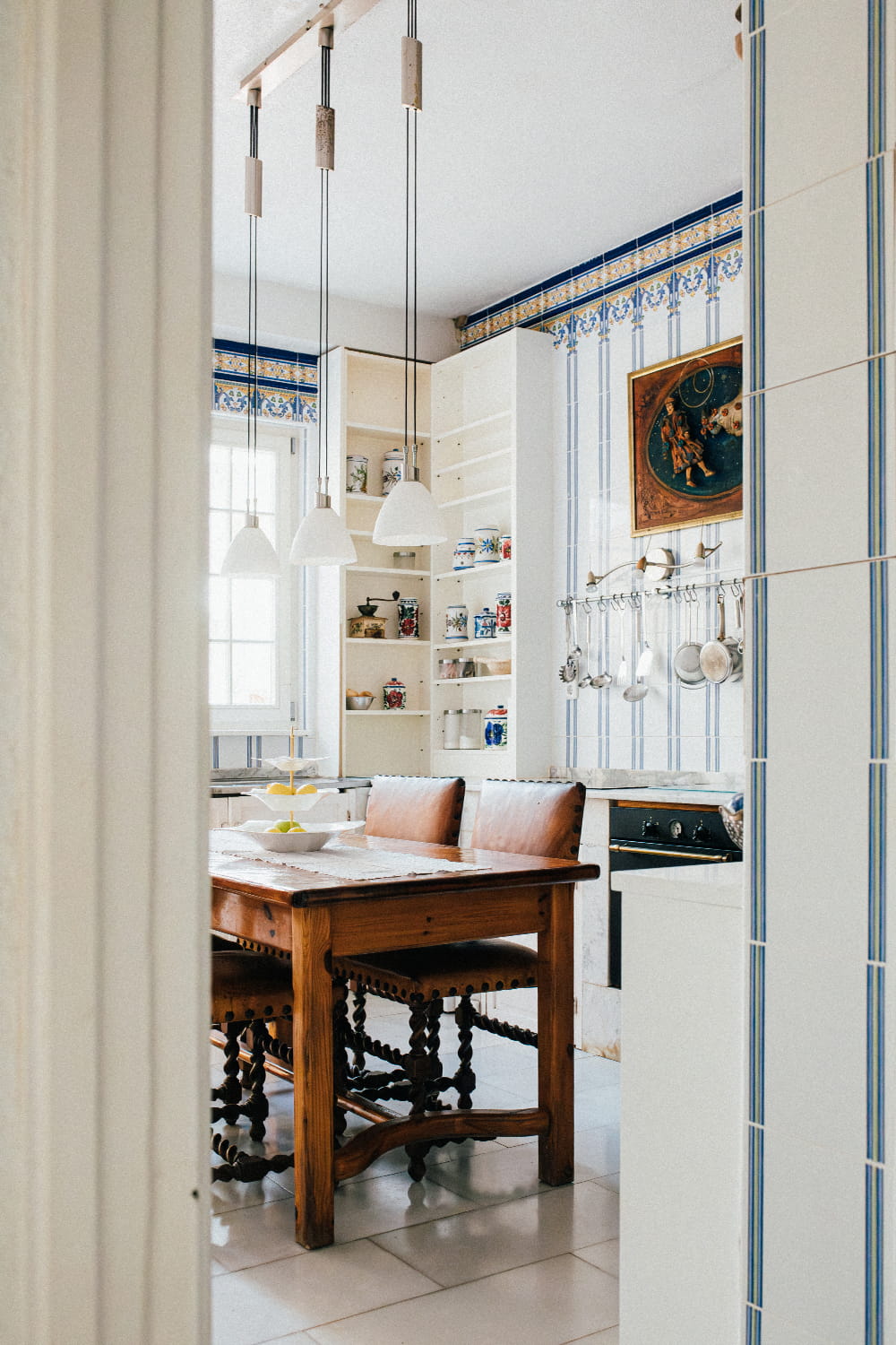 Fotografía de cocina tradicional con azulejos decorativos y mesa de madera maciza