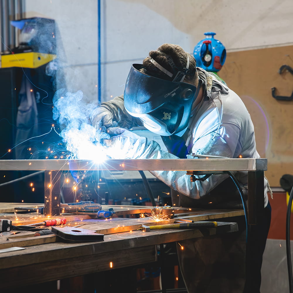 Operario de Serigrafic soldando estructura metálica en taller de rotulación