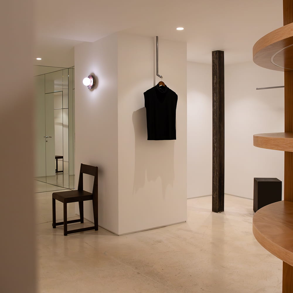 Interior minimalista de tienda de ropa con mobiliario de diseño y prenda expuesta