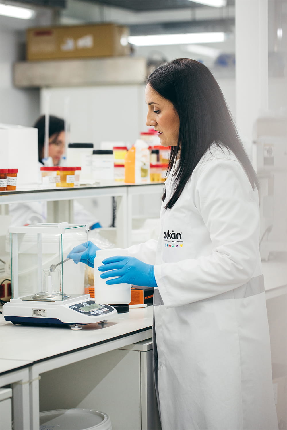 Técnica de laboratorio de Zukán realizando análisis y pesaje de muestras en entorno industrial