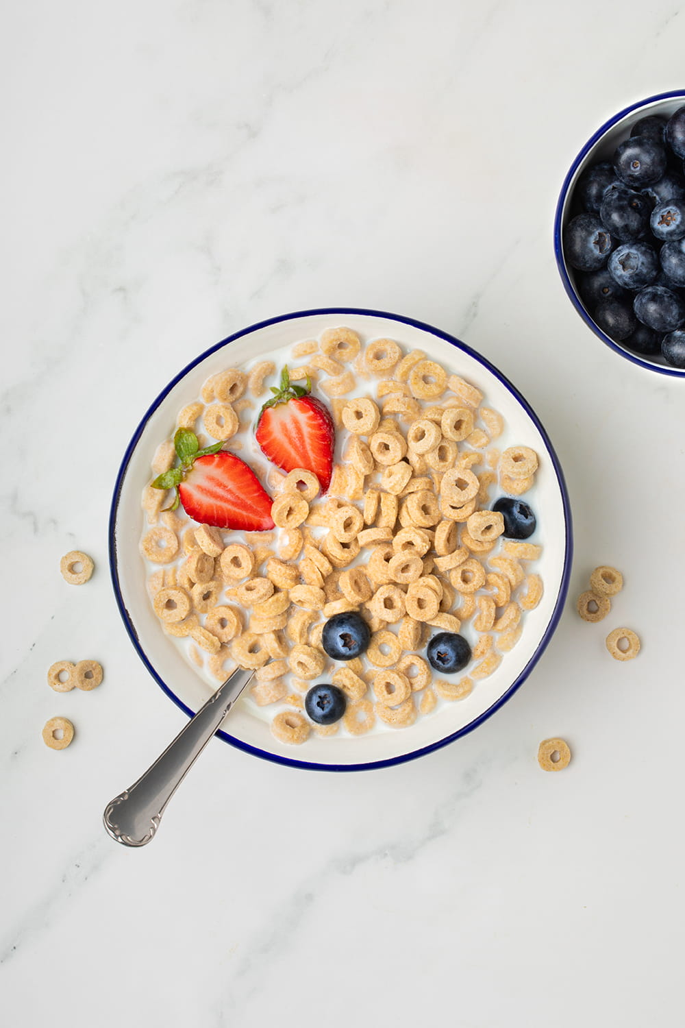 Fotografía cenital de bol de cereales con fresas y arándanos para packaging de alimentación realizada por Cristina Navarro