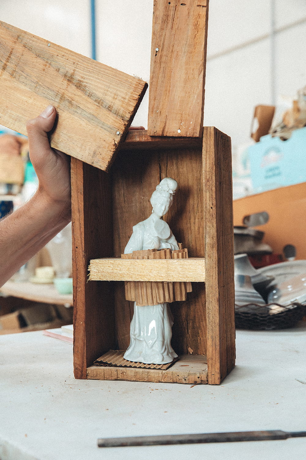 Vista de la figura de mujer de porcelana blanca entera, de pies a cabeza, intacta y llena de detalle, dentro de su caja de madera original rústica y abierta